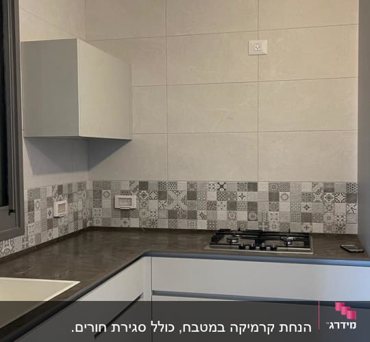מטבח משופץ עם ארונות לבנים וכיריים חדשות